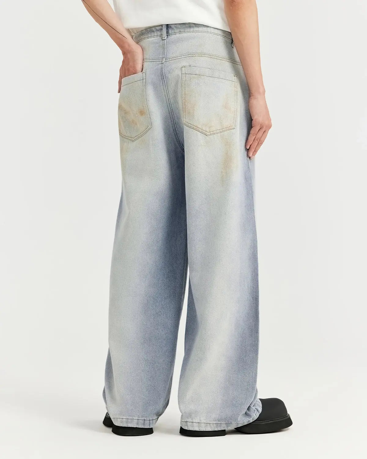 Mud washed baggy jeans by INFLATION Streetwear, showing relaxed fit with distressed details and faded denim finish.