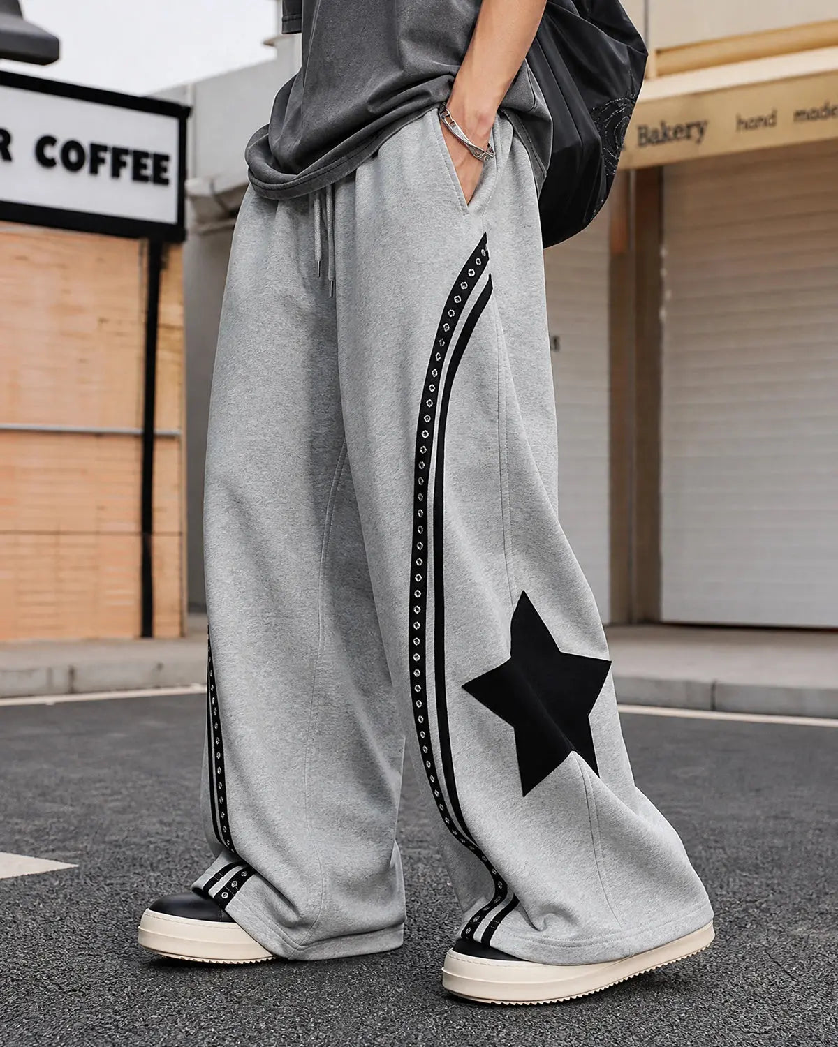 Contrast patchwork barrel sweatpants by INFLATION featuring mixed fabric panels and a relaxed streetwear style.