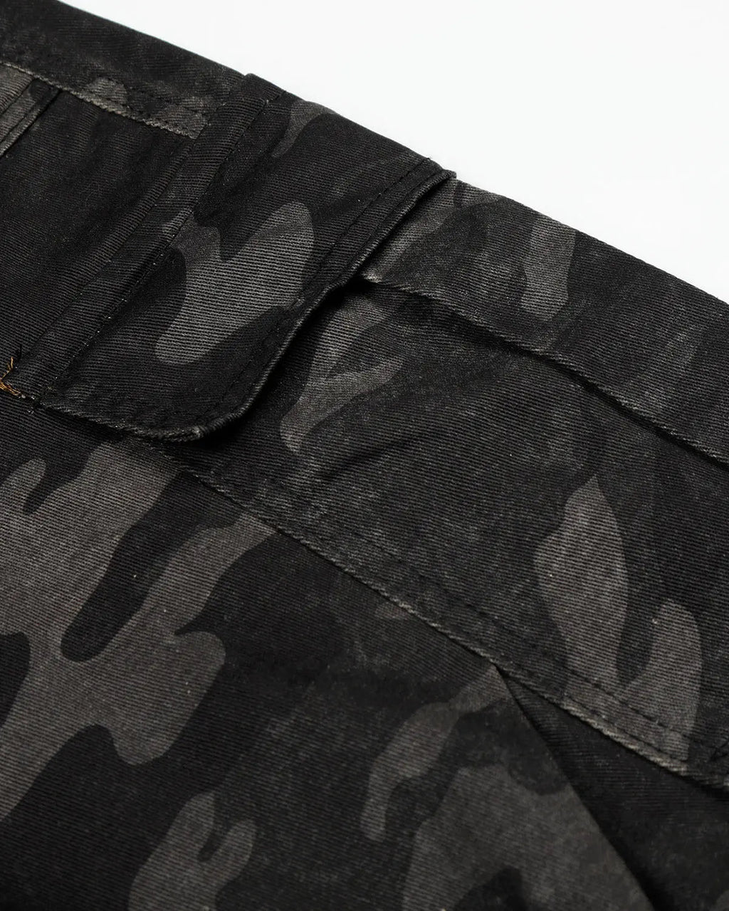Dark camo cargo shorts by INFLATION, showing the relaxed fit and multiple pockets of the streetwear pants.