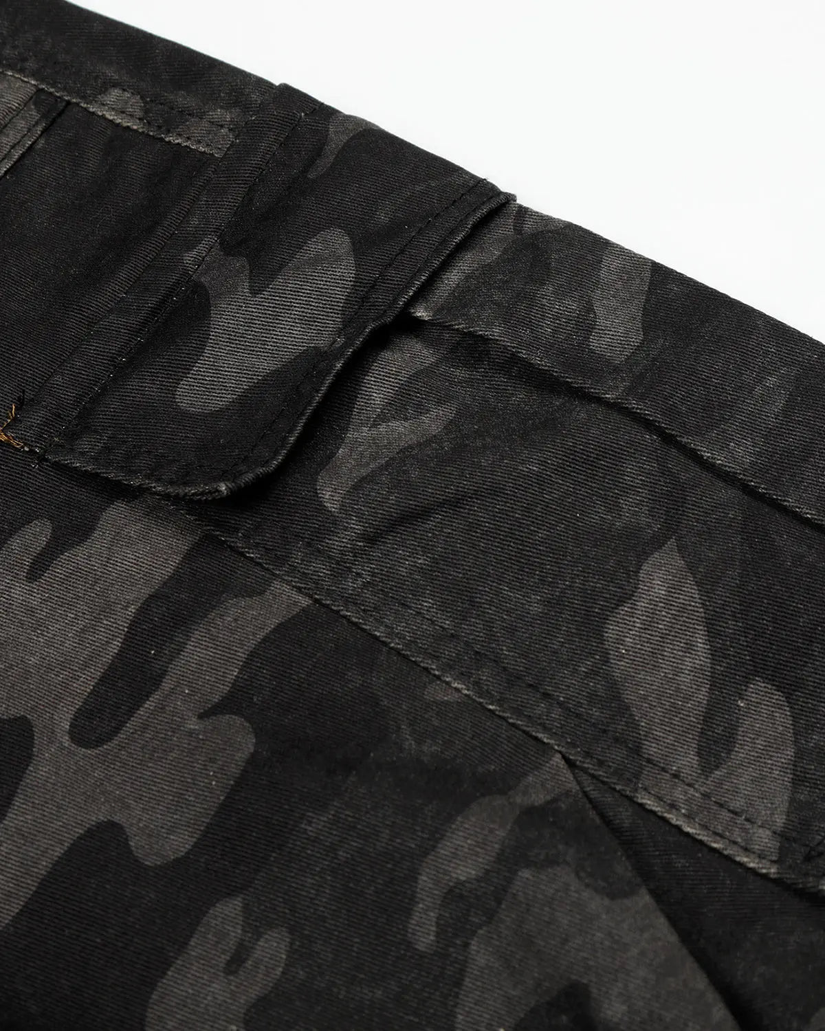 Dark camo cargo shorts by INFLATION, showing the relaxed fit and multiple pockets of the streetwear pants.
