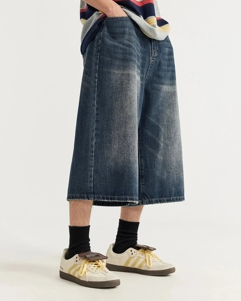 Acid washed longline baggy denim jorts by INFLATION, relaxed fit pants with distressed detailing, styled with rolled cuffs and casual look.