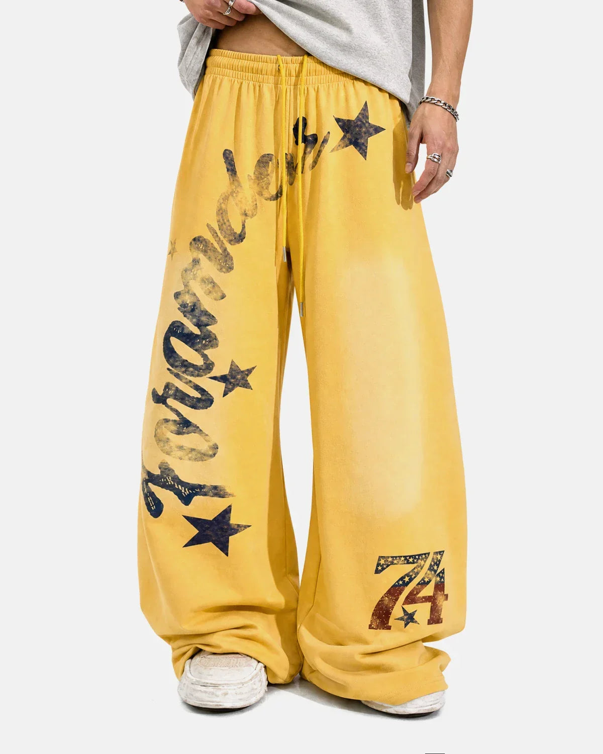 Black star graphic barrel sweatpants by INFLATION with a relaxed fit and bold star design on front, made from comfortable fabric.
