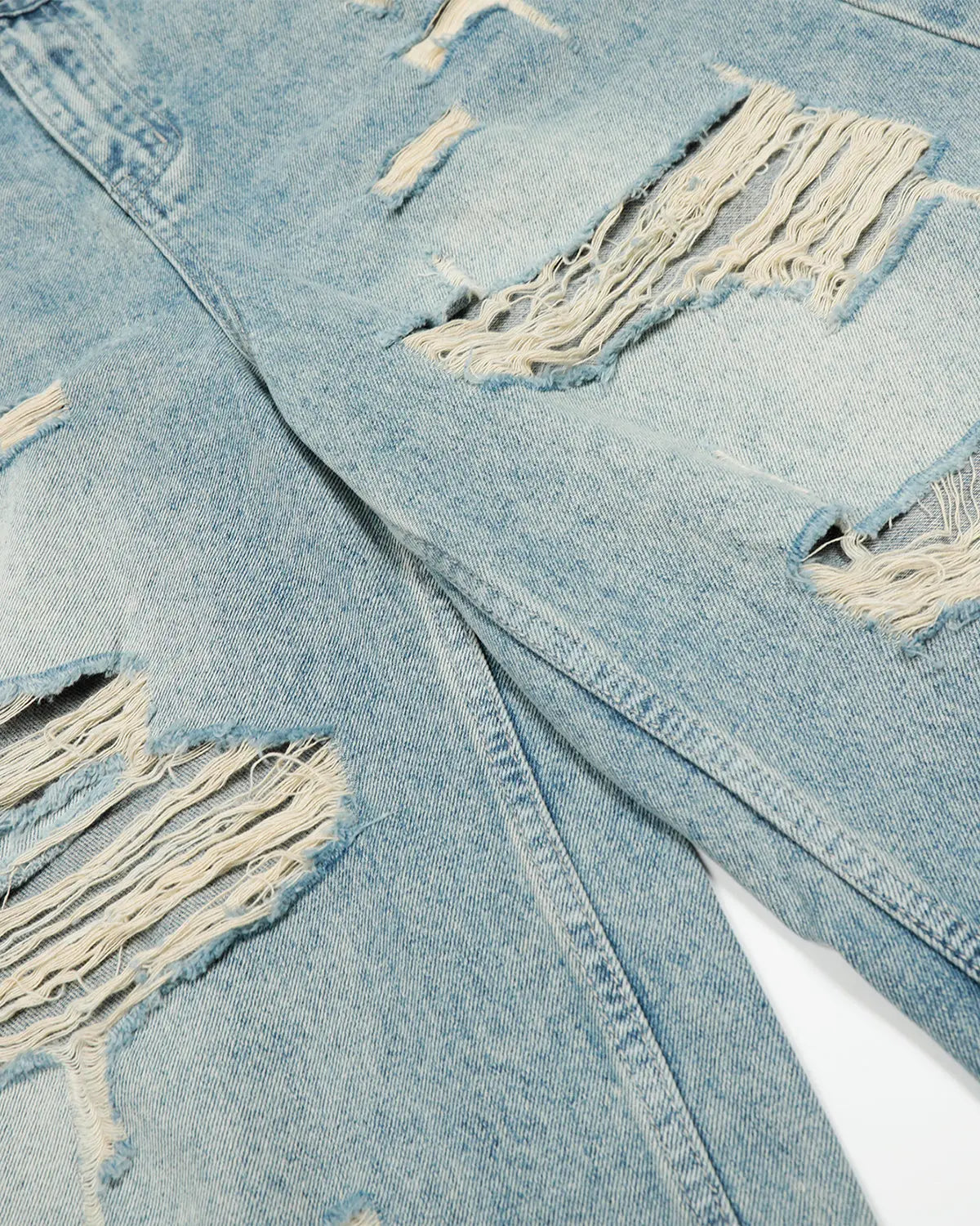 Distressed longline jorts by Inflation Streetwear, denim pants with frayed edges and a relaxed fit, styled for casual streetwear.