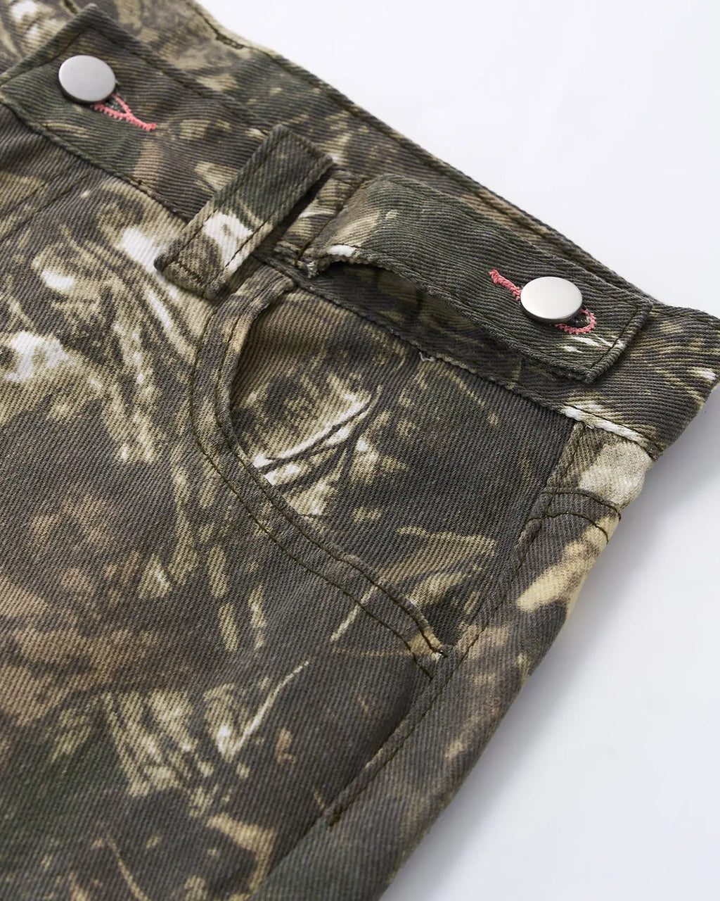 Pink embroidered camo baggy pants by INFLATION, featuring loose fit, camouflage pattern, and detailed embroidery on the fabric.