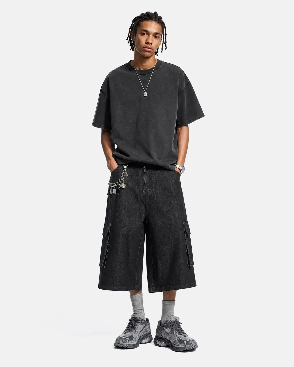 Black cargo longline jorts by INFLATION featuring a relaxed fit with multiple pockets and distressed denim details.