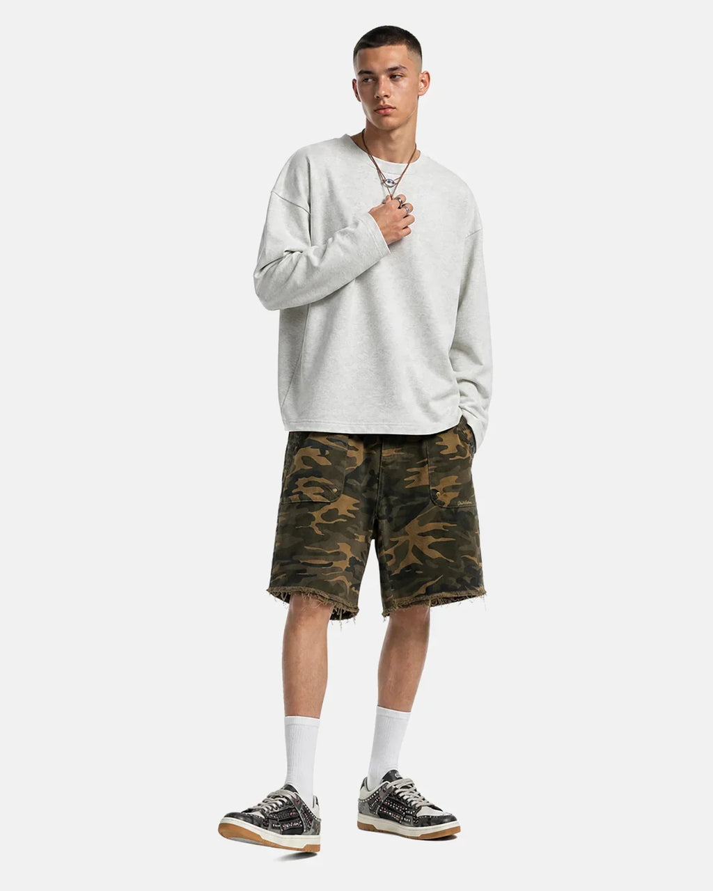 Inflation streetwear frayed hem camo knee-length shorts with distressed edges and camouflage pattern, casual summer men's fashion.