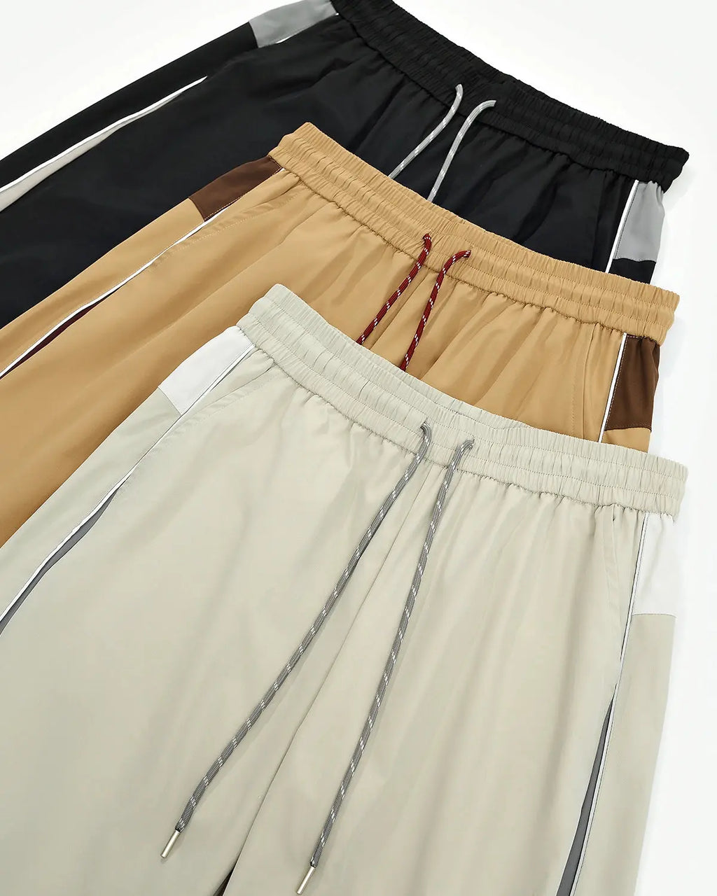 Reflective windbreaker track pants by INFLATION, featuring a sleek design with reflective details and athletic fit.