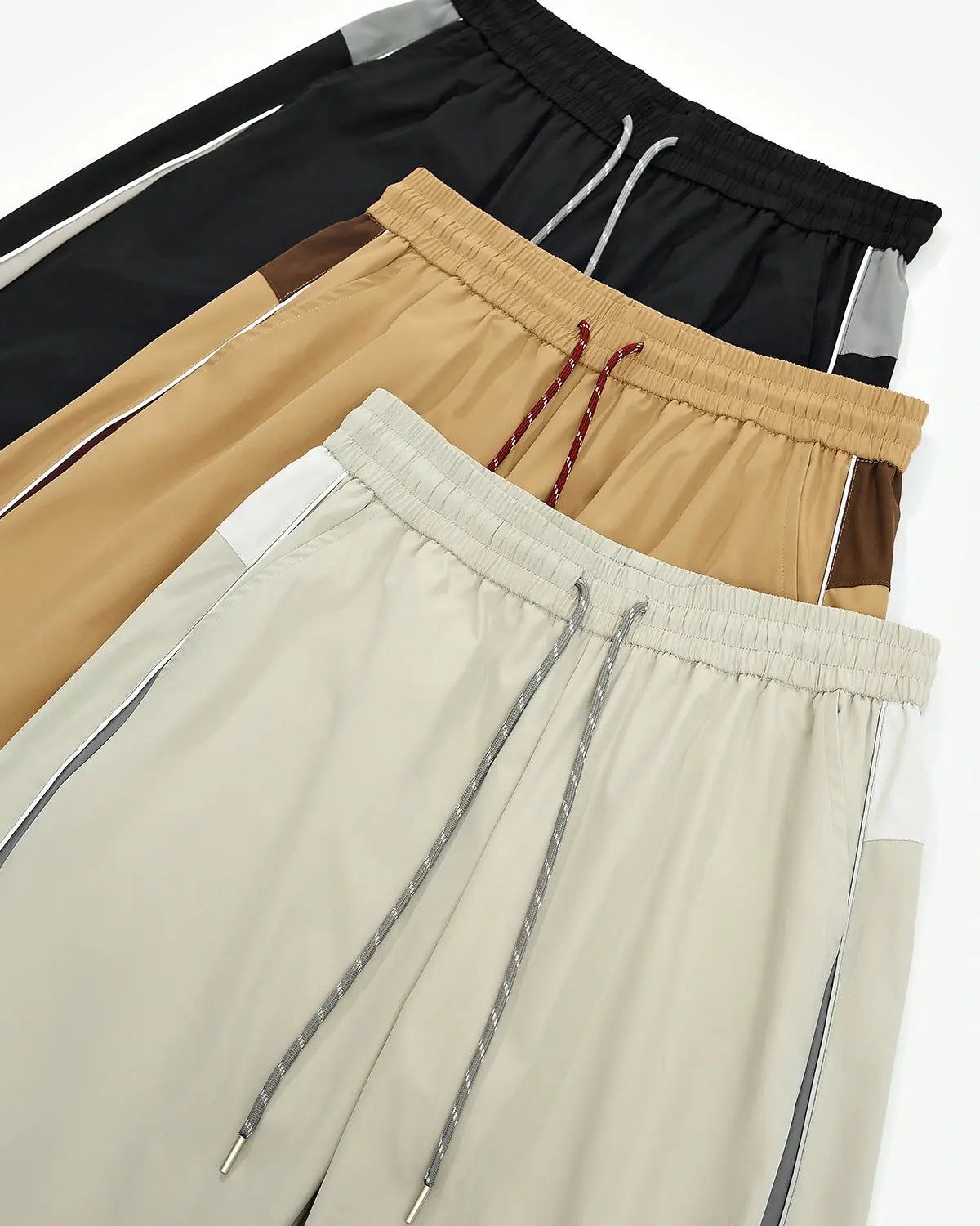 Reflective windbreaker track pants by INFLATION, featuring a sleek design with reflective details and athletic fit.