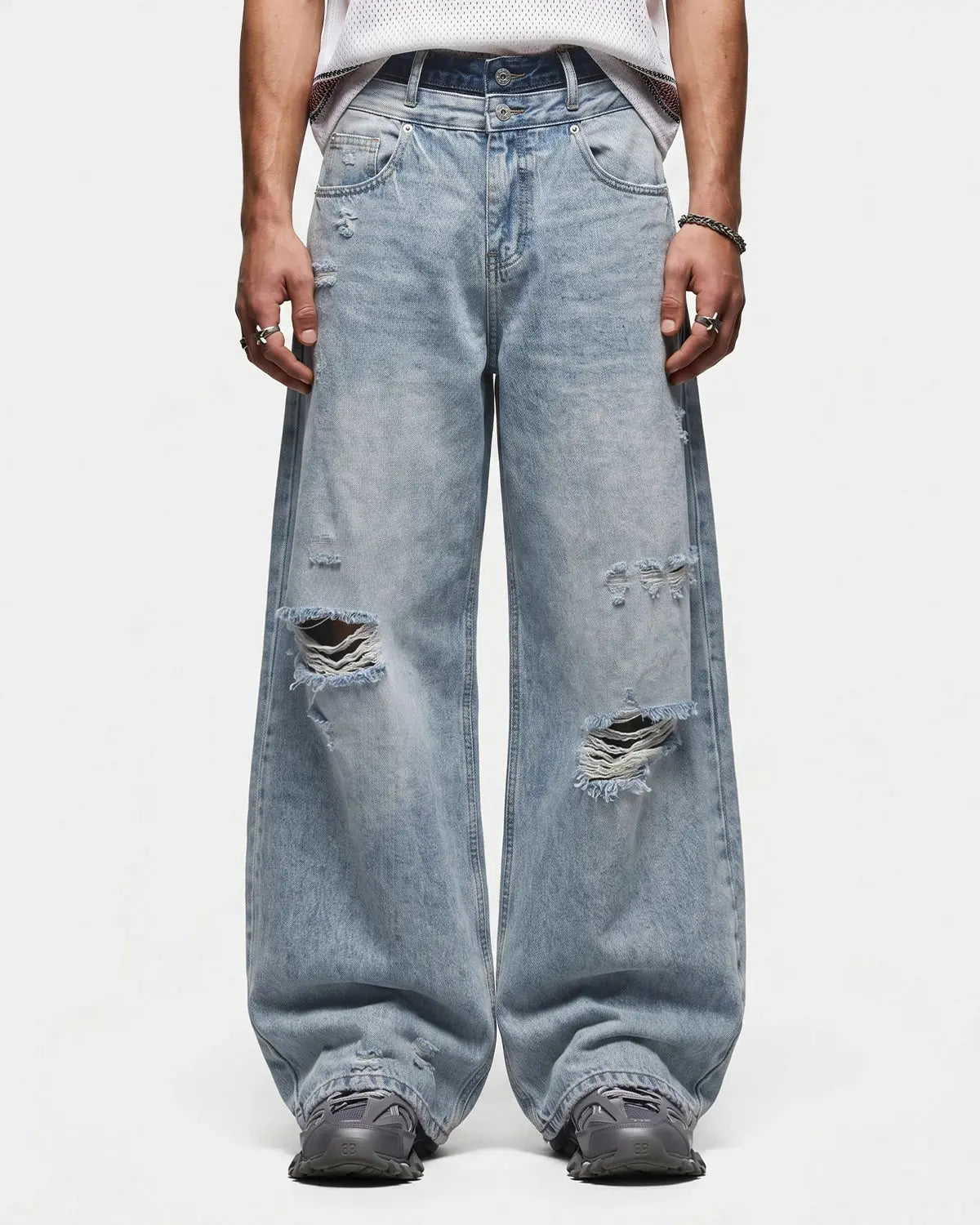 Light blue double waist distressed baggy jeans by INFLATION with ripped details and relaxed fit, displayed on a neutral background.