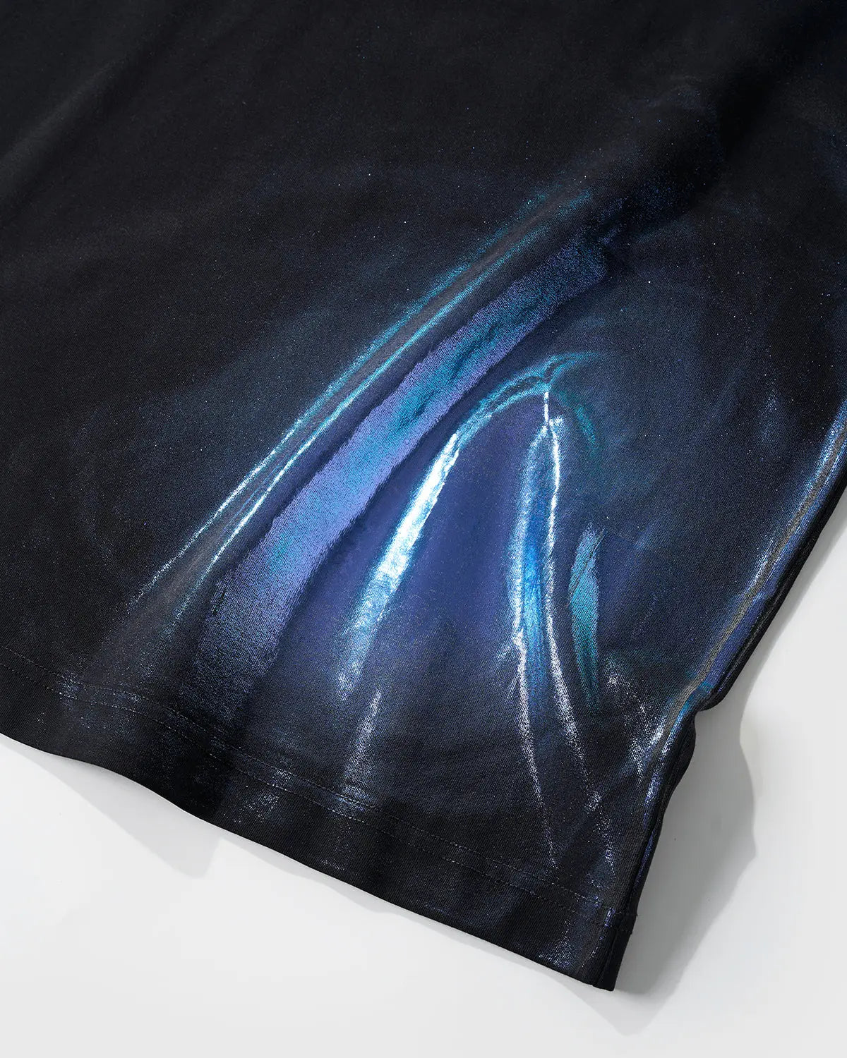 Iridescent shimmer oversized T-shirt by INFLATION, featuring a reflective, colorful fabric and relaxed fit, shown on a model.
