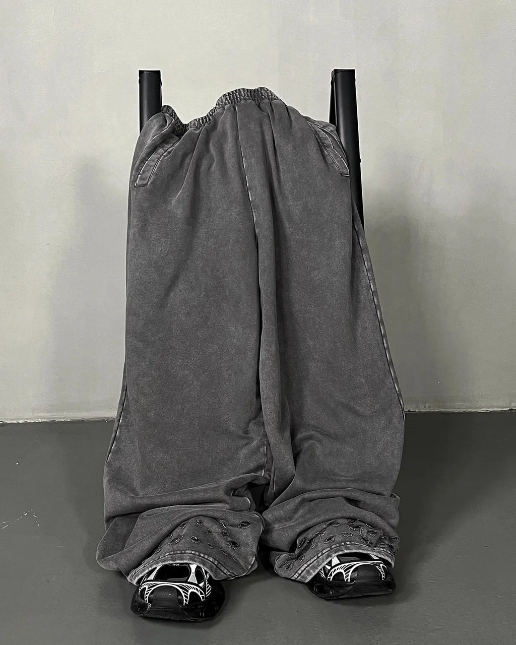 Inflation streetwear ripped acid wash sweatpants with distressed detailing and relaxed fit, shown in a casual streetwear style.