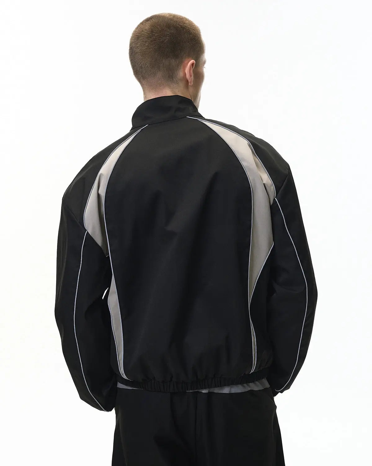 Reflective windbreaker track jacket by INFLATION with sleek design, lightweight fabric, and reflective accents for visibility.