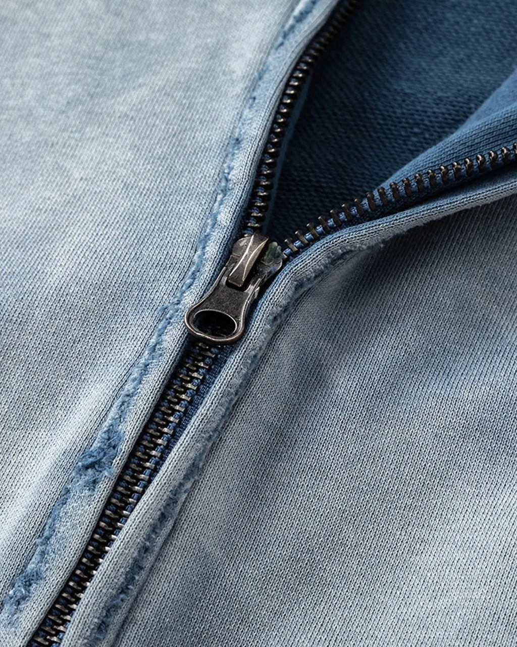 Blue distressed acid wash zip-up hoodie by INFLATION, featuring a casual streetwear style with a relaxed fit.