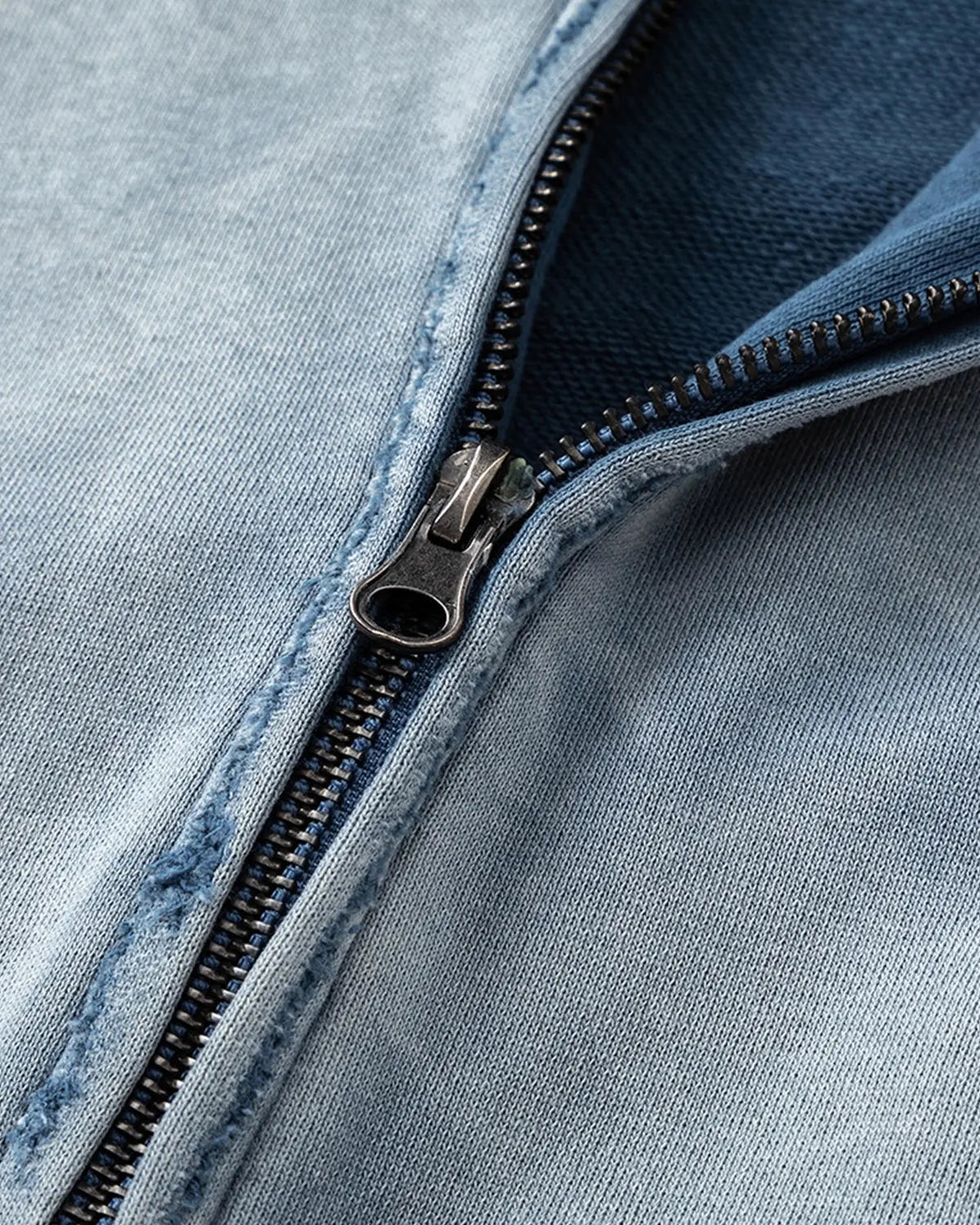 Blue distressed acid wash zip-up hoodie by INFLATION, featuring a casual streetwear style with a relaxed fit.
