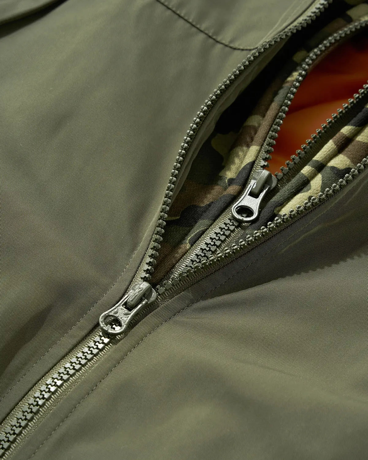 Detachable layered camo bomber jacket by INFLATION featuring a streetwear-inspired design with layered camouflage details.