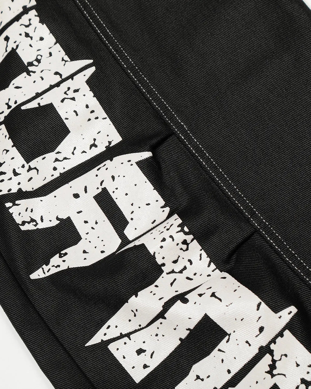 Letter graphic cargo barrel jeans by INFLATION featuring streetwear style, with visible cargo pockets and distressed denim details.