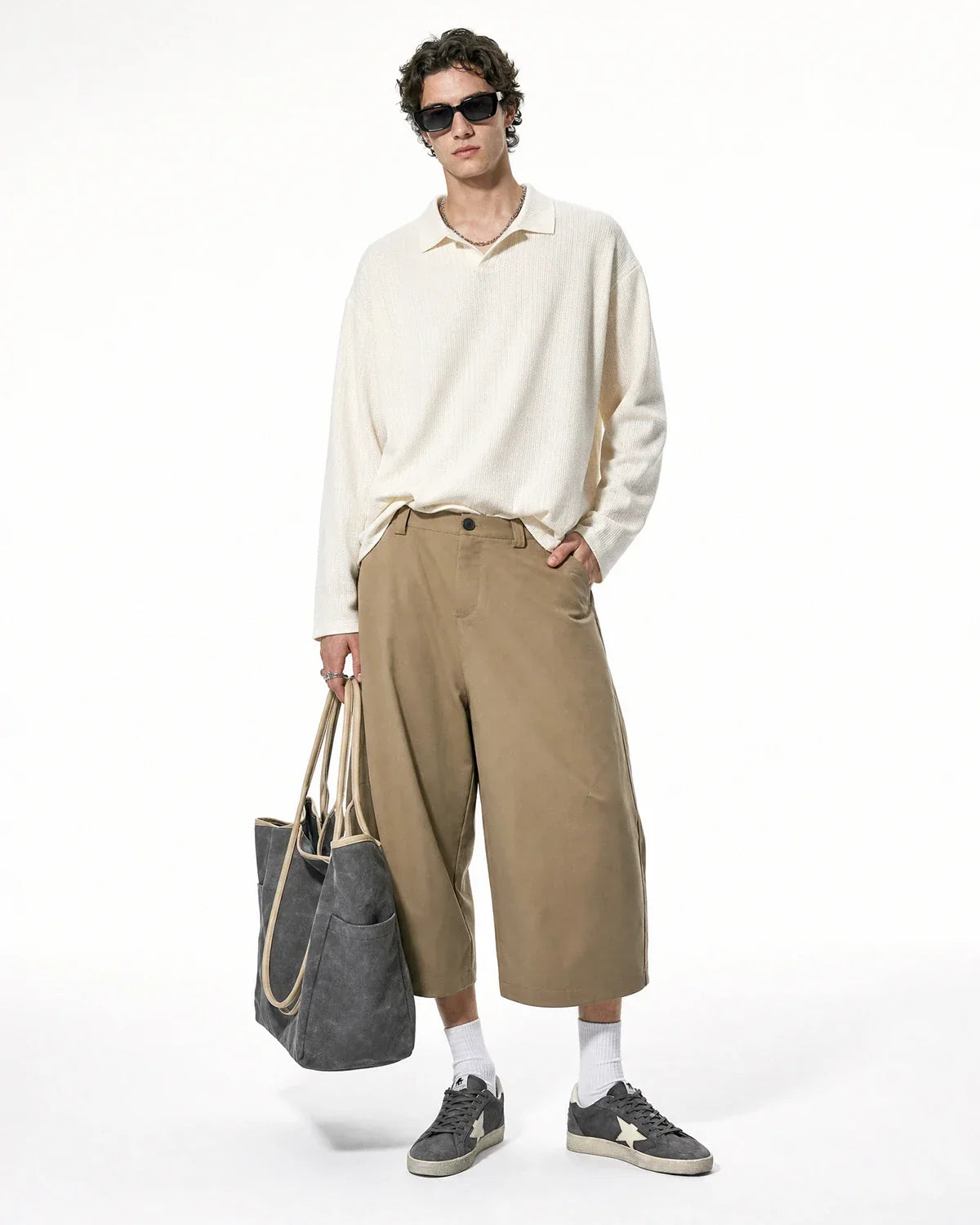 Inflation Streetwear pleated barrel tailored Bermuda shorts in beige, featuring a high waist and relaxed fit, shown on a model.