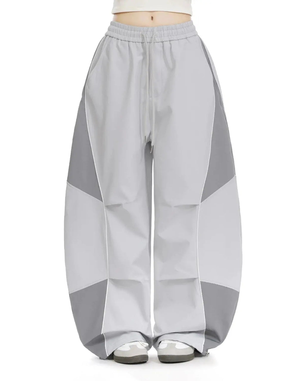 Inflation Streetwear contrast panel baggy track pants with black and white panels, relaxed fit, and logo details.