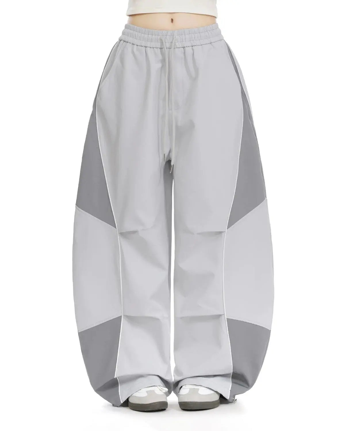 Inflation Streetwear contrast panel baggy track pants with black and white panels, relaxed fit, and logo details.