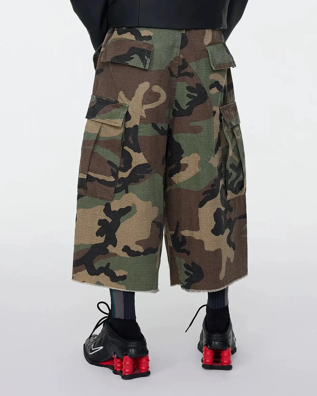 Inflation Streetwear oversized camo cargo longline shorts with multiple pockets and relaxed fit, featuring a bold camouflage pattern.
