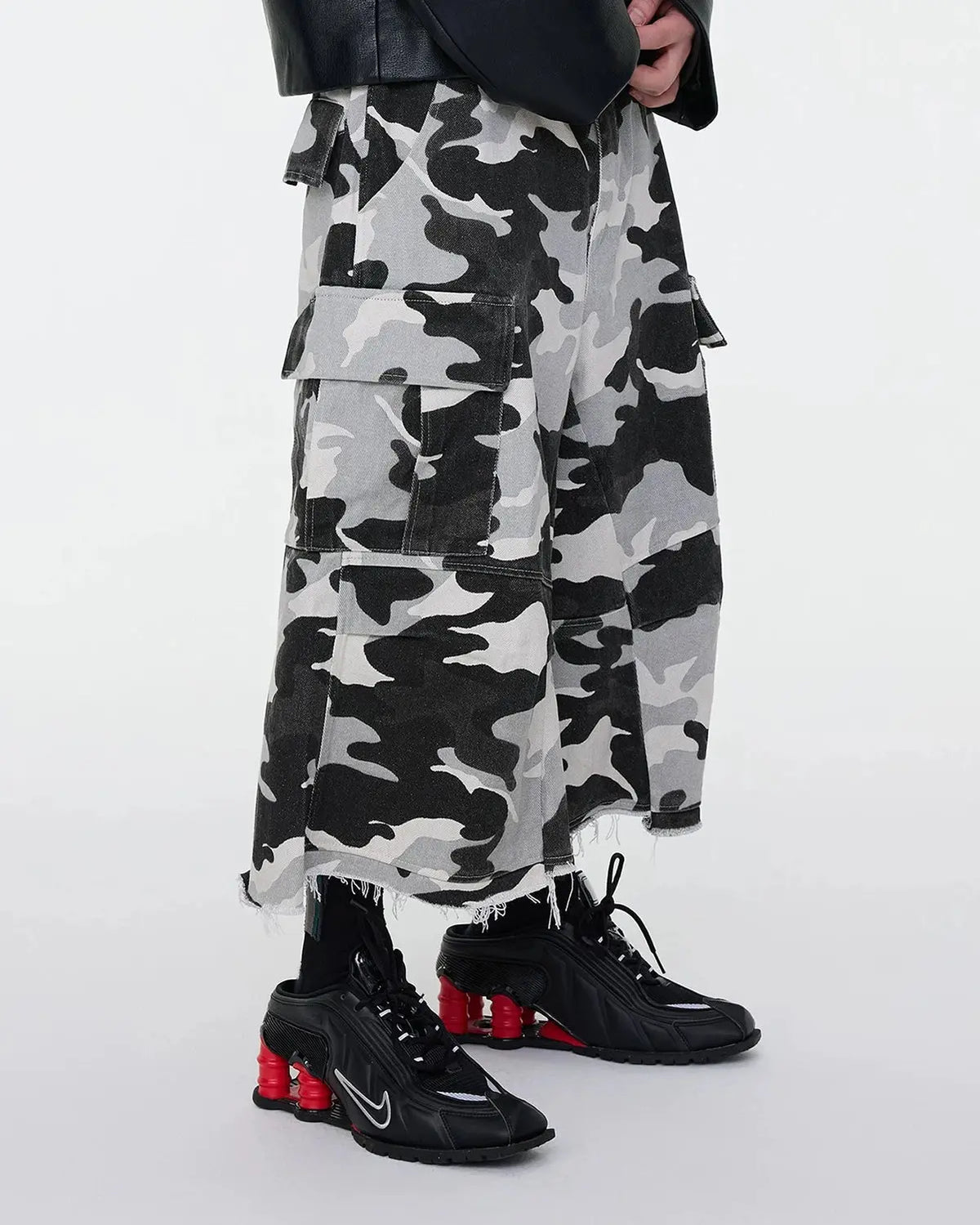 Glitter camo cargo longline shorts by INFLATION, stylish pants with a glittery camo pattern and oversized fit.