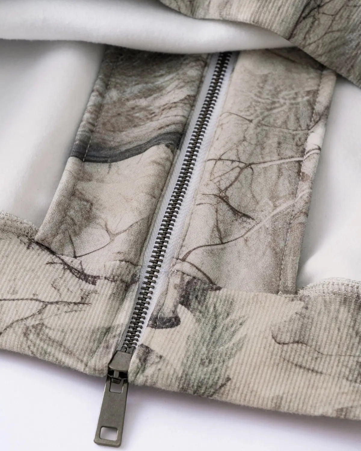 Inflation Streetwear Realtree camo zip-up hoodie with front pockets and adjustable drawstring hood on a model.