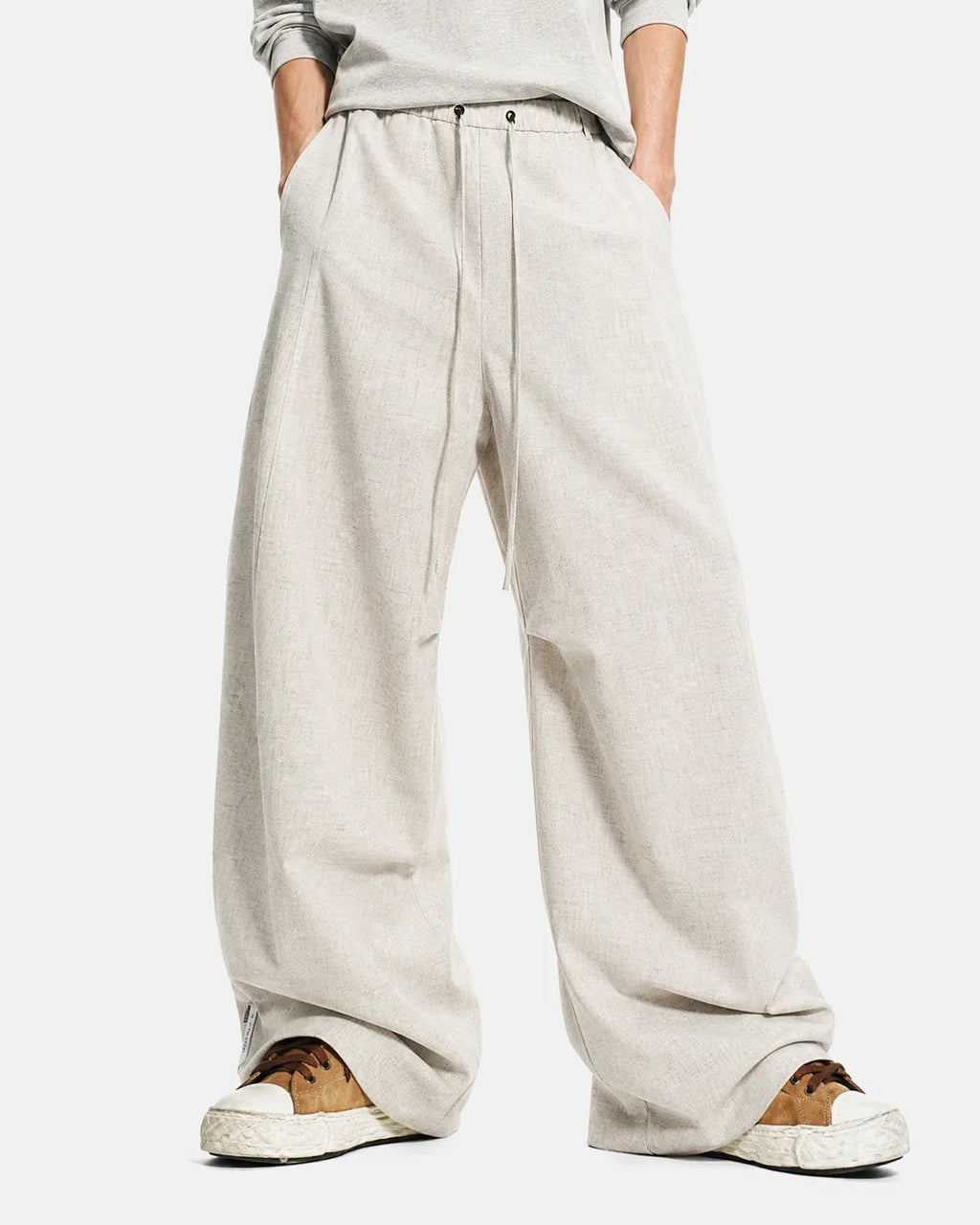 Light beige cotton linen wide-leg pants by Inflation Streetwear laid flat, showcasing relaxed fit and flowy fabric.
