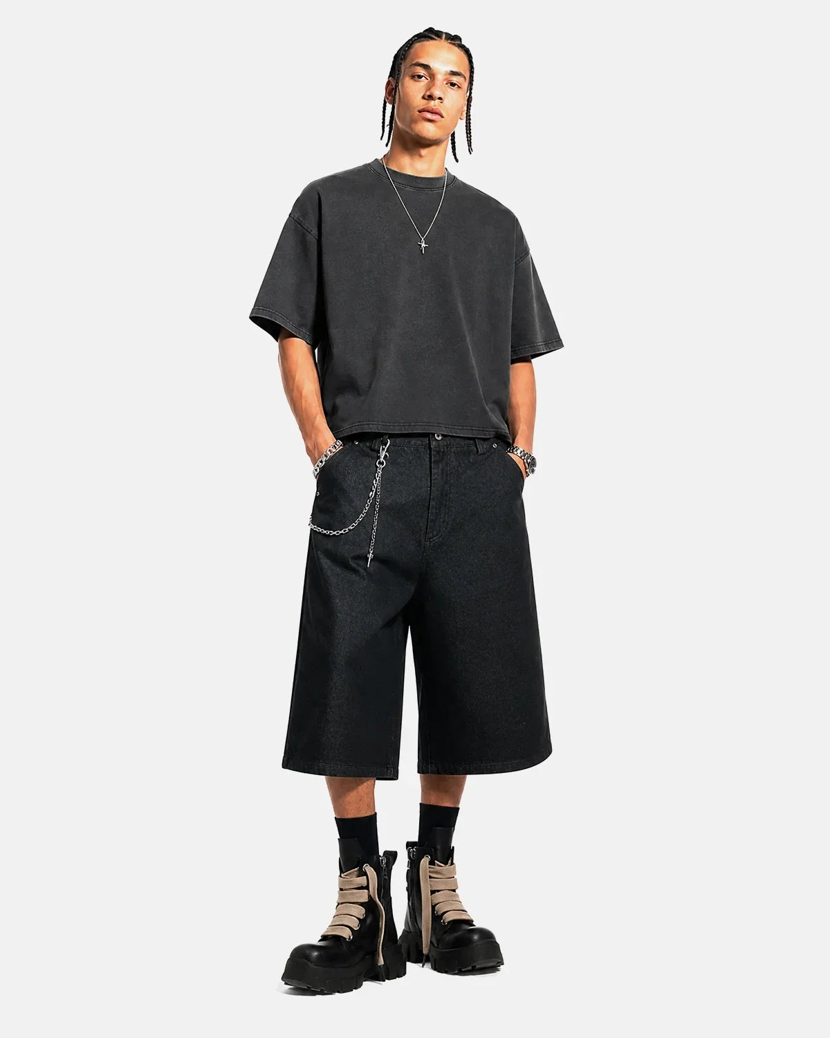 Black baggy long jorts by INFLATION featuring a relaxed fit, distressed denim look, and casual streetwear style.