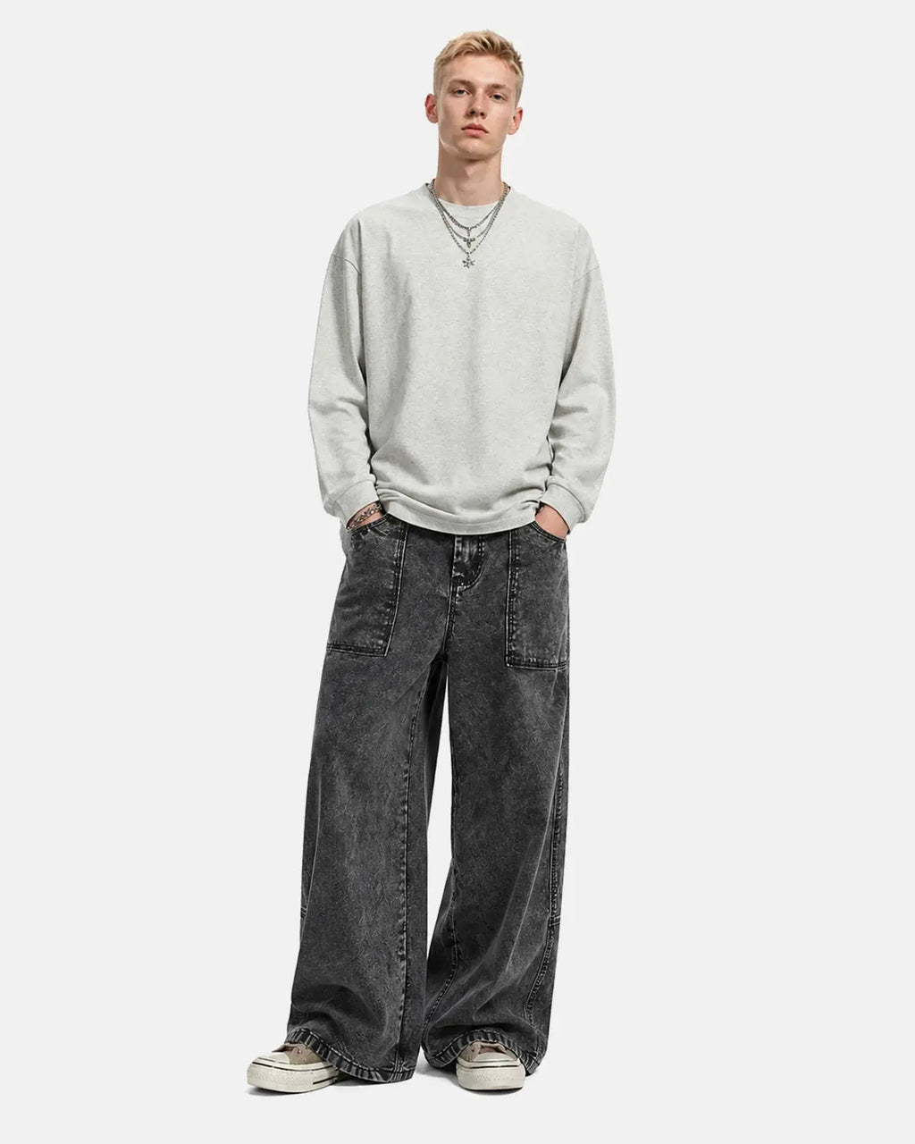 Deconstructed distressed barrel jeans by INFLATION featuring rugged design and frayed details, styled on a model.