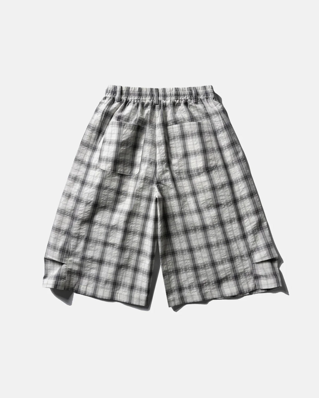 Inflation brand plaid longline casual shorts with a relaxed fit and blue, red, and white checkered pattern on lightweight fabric.
