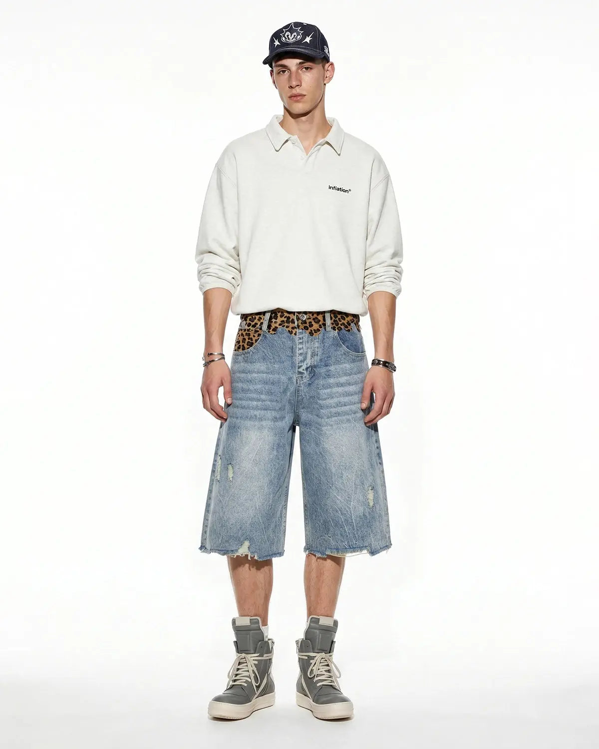 Leopard patchwork jorts by INFLATION featuring distressed denim with leopard print accents and casual cut for streetwear style.