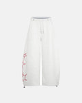Gothic script baggy sweatpants by INFLATION featuring a relaxed fit and streetwear style, shown in dark fabric with bold lettering.