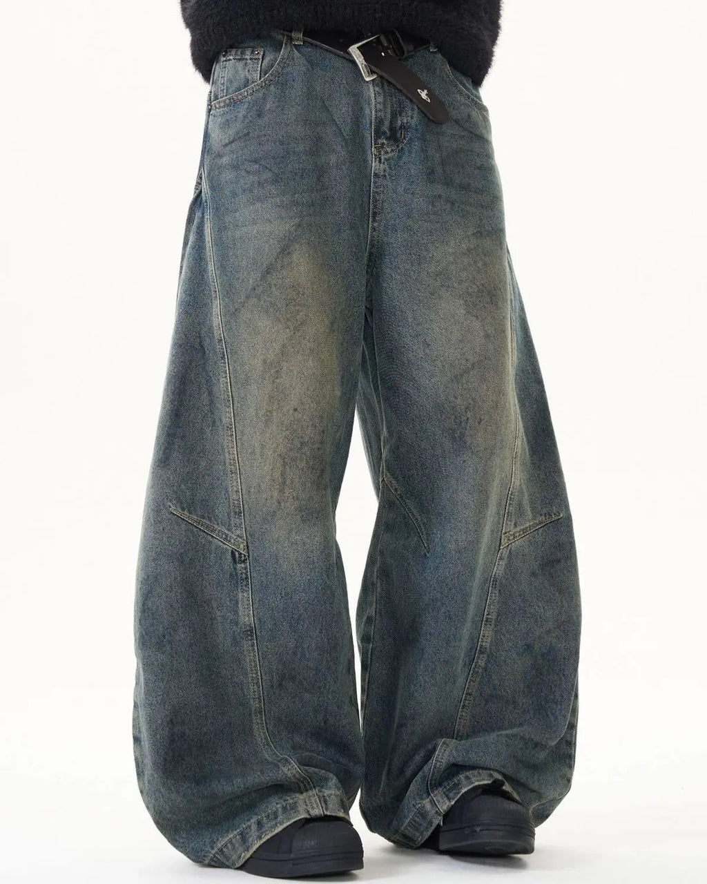 Washed deconstructed barrel jeans by INFLATION, streetwear style with distressed details and relaxed fit, shown on a model.