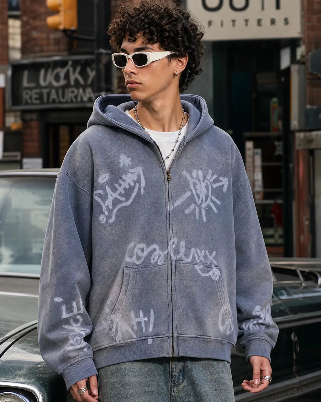 INFLATION graffiti washed zip-up hoodie featuring a colorful graffiti design on the front, with a hood and front pockets.