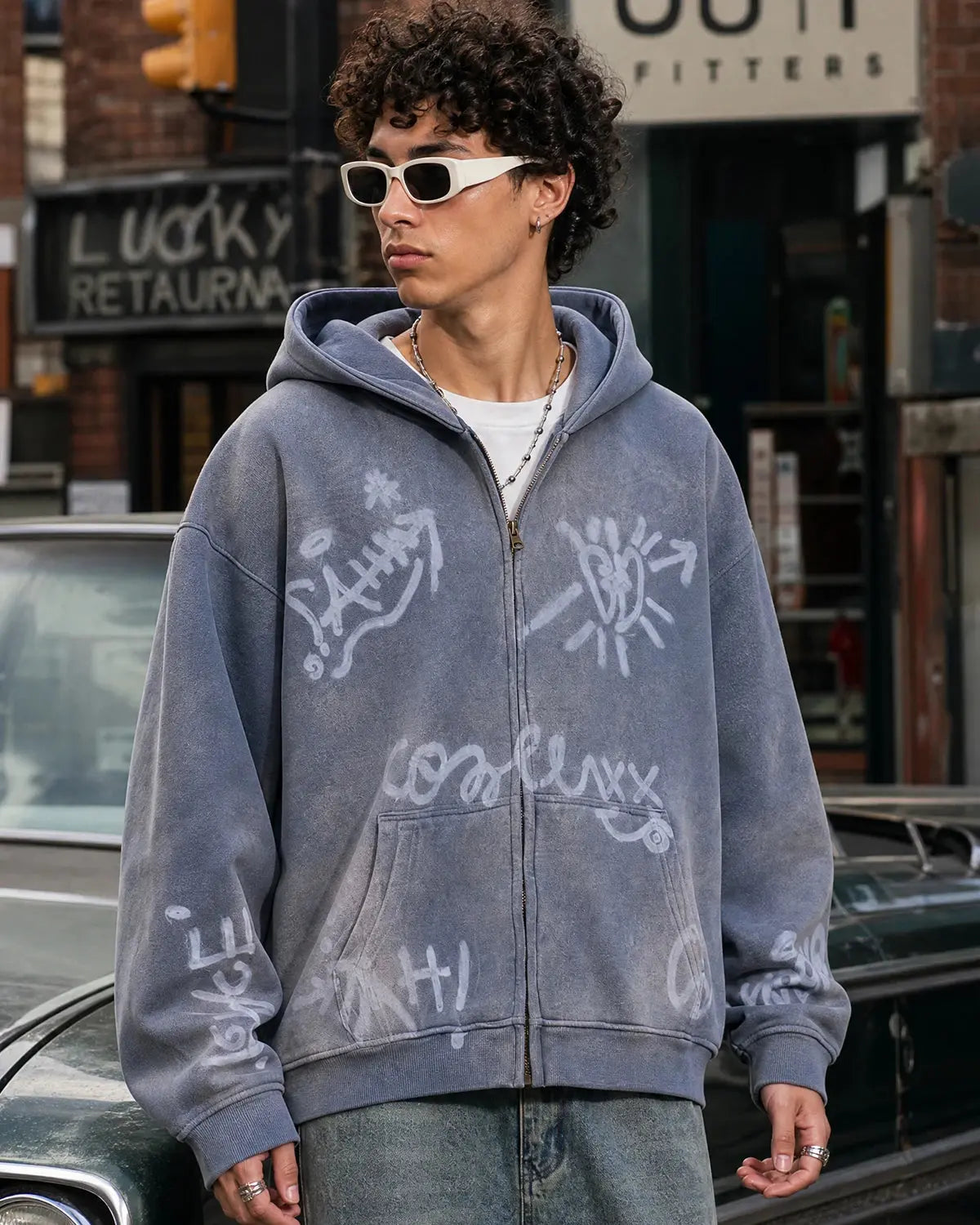 INFLATION graffiti washed zip-up hoodie featuring a colorful graffiti design on the front, with a hood and front pockets.