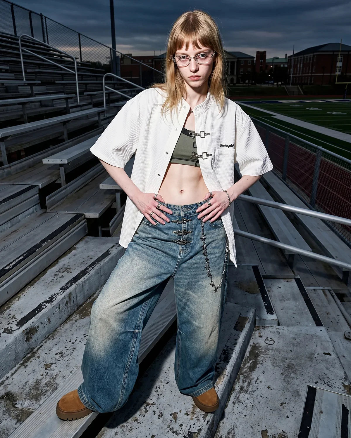 Asymmetric buckle denim overalls jeans by INFLATION featuring unique design, distressed details, and classic blue denim fabric.
