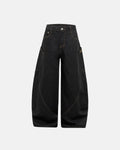 Inflation Super Raw Barrel Jeans in dark denim, featuring a relaxed fit and raw hem, styled with a casual streetwear look.
