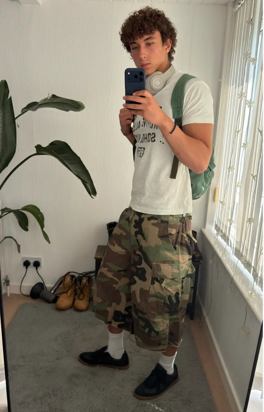 Oversized camouflage cargo longline shorts by INFLATION Streetwear featuring multiple pockets and relaxed fit.