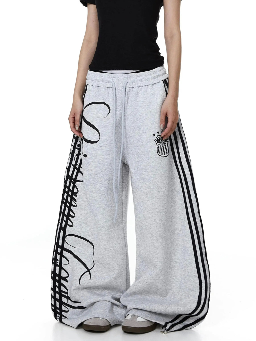 Inflation Script Stripe Baggy Sweatpants shown in black, featuring a relaxed fit and bold script stripe design on soft cotton fabric.