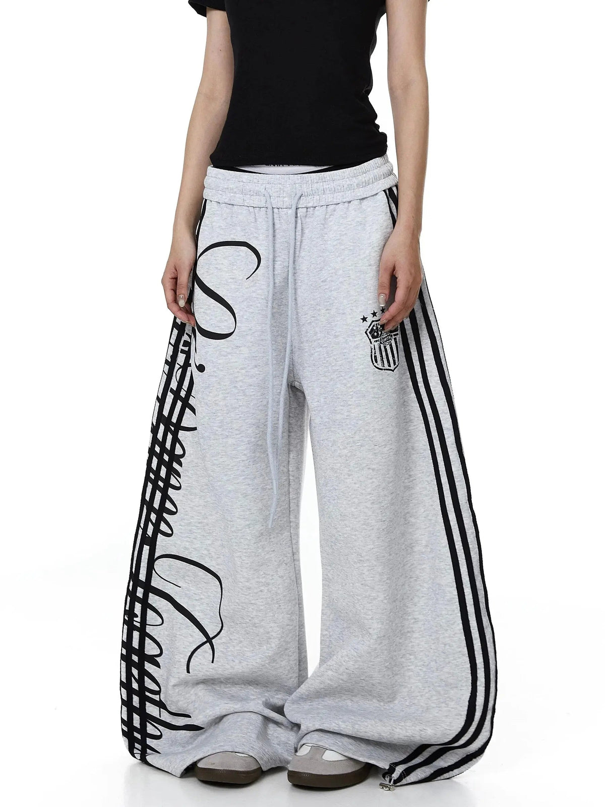 Inflation Script Stripe Baggy Sweatpants shown in black, featuring a relaxed fit and bold script stripe design on soft cotton fabric.