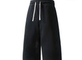 Inflation trending long jogger shorts in black, featuring a relaxed fit, elastic waistband, and side pockets on a model.