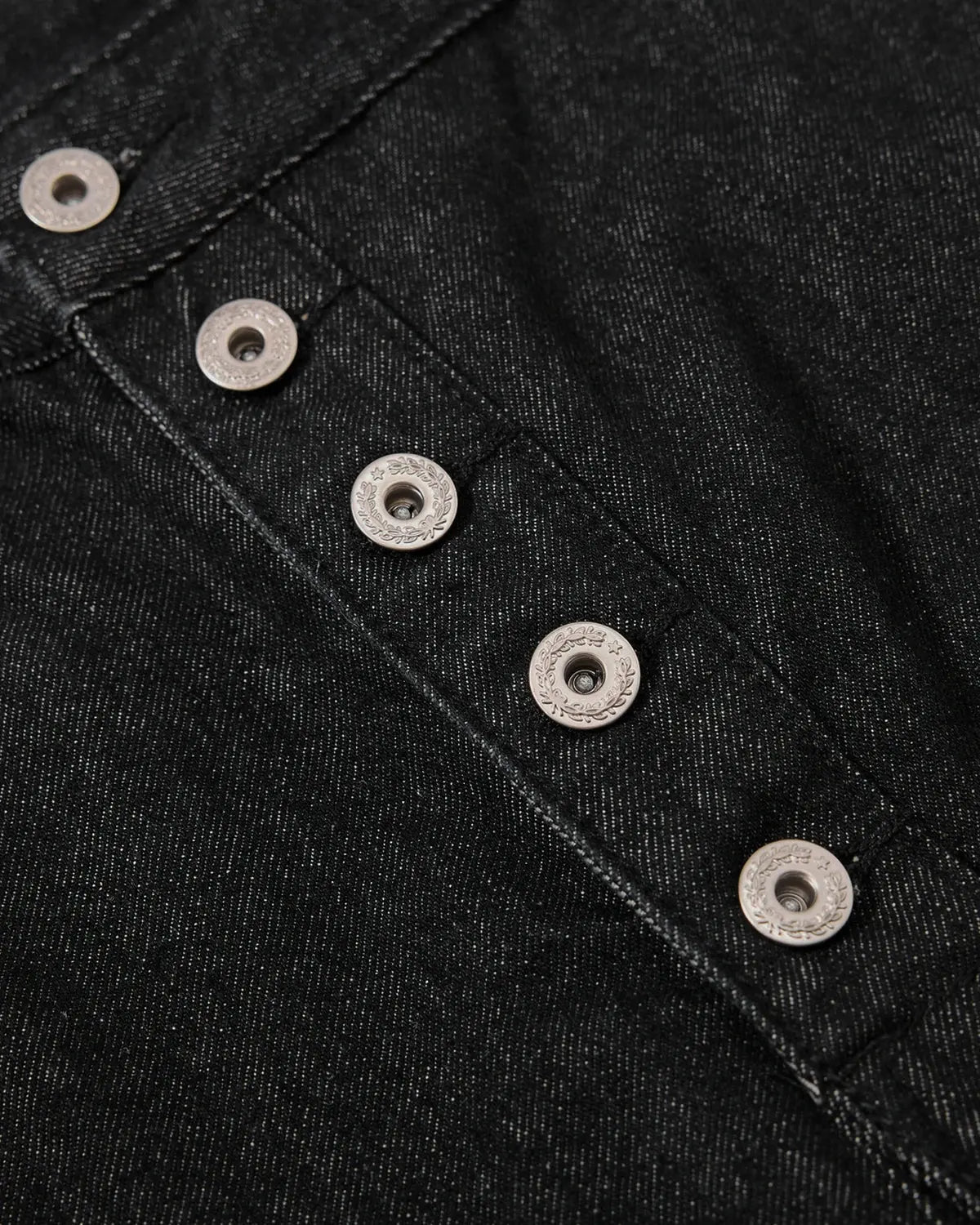 Asymmetric raw denim jorts by INFLATION featuring button details and distressed raw hem, casual streetwear pants.