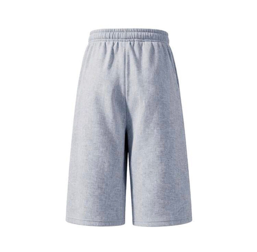 Inflation trending long jogger shorts in black, featuring a relaxed fit and elastic waistband, suitable for casual wear.