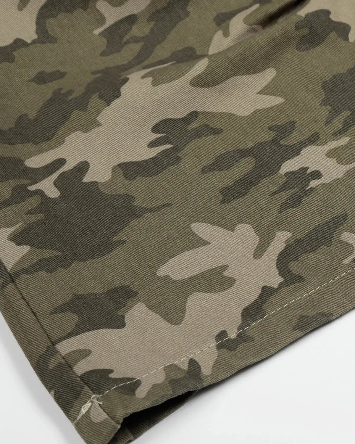 Embroidered camo cargo longline shorts by INFLATION featuring military-style camouflage pattern and casual fit.