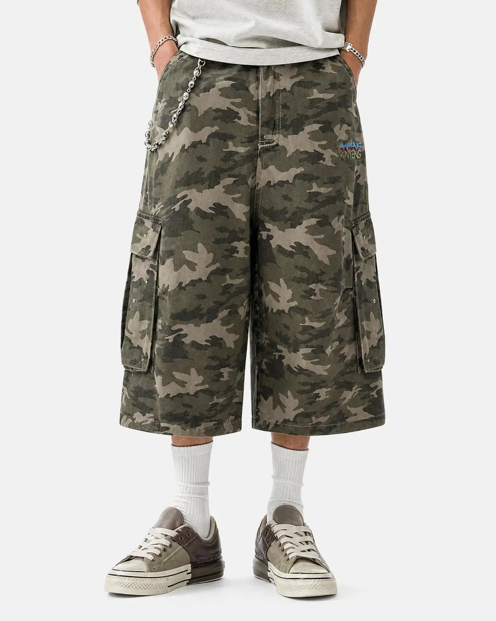 Embroidered camo cargo longline shorts by INFLATION, featuring camouflage print, multiple pockets, and a relaxed fit.
