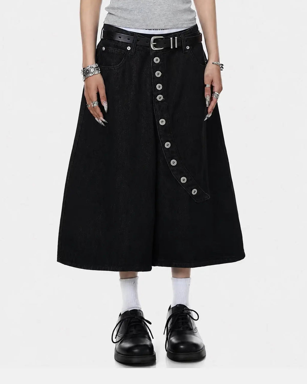 Asymmetric button raw denim jorts by INFLATION featuring distressed details and raw hem, styled as casual streetwear pants.