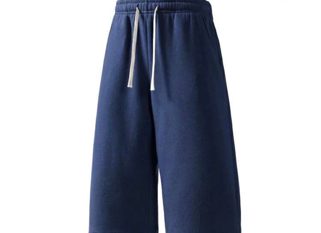 Inflation trending long jogger shorts in black, featuring an elastic waistband and relaxed fit, suitable for casual wear.