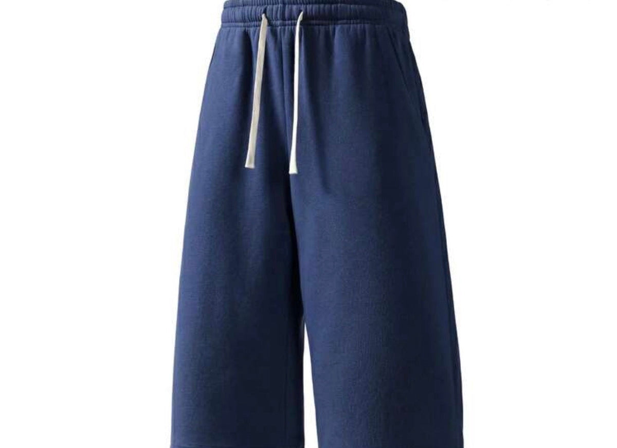 Inflation trending long jogger shorts in black, featuring an elastic waistband and relaxed fit, suitable for casual wear.