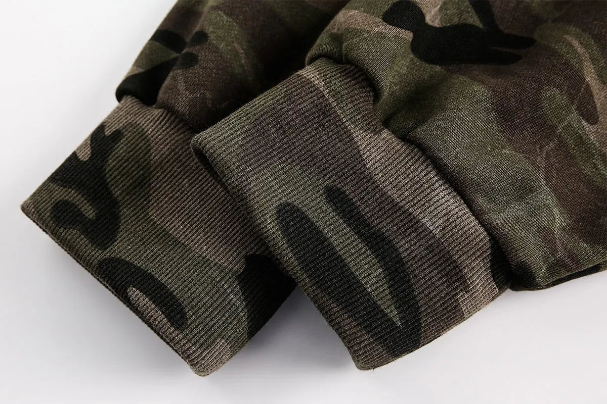 Inflation Streetwear camouflage zip-up jacket with hood, featuring green and brown military print and front pockets.